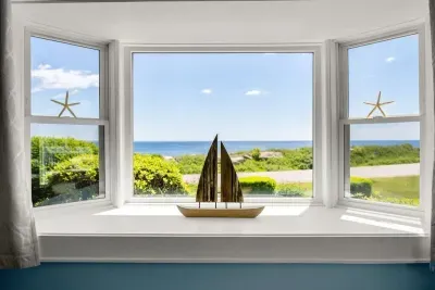 Open kitchen & living room with sleeper sofa, 50" smart TV, high-efficiency mini-split for AC/heat, and stunning views of the ocean.