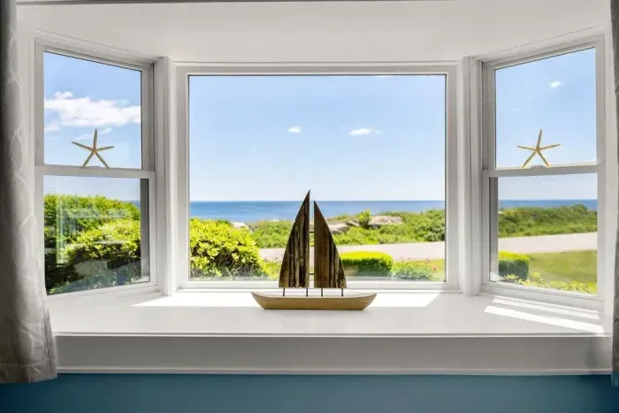 Open kitchen & living room with sleeper sofa, 50" smart TV, high-efficiency mini-split for AC/heat, and stunning views of the ocean.