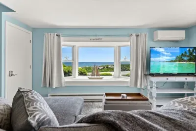 Open kitchen & living room with sleeper sofa, 50" smart TV, high-efficiency mini-split for AC/heat, and stunning views of the ocean.