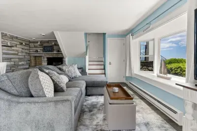 Open kitchen & living room with sleeper sofa, 50" smart TV, high-efficiency mini-split for AC/heat, and stunning views of the ocean.