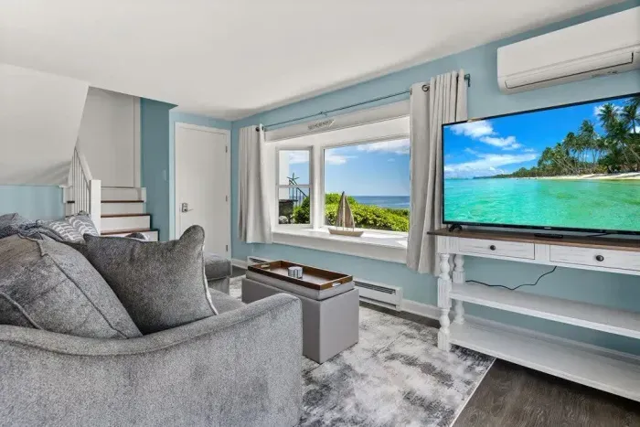 Open kitchen & living room with sleeper sofa, 50" smart TV, high-efficiency mini-split for AC/heat, and stunning views of the ocean.