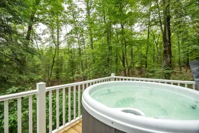 The hot tub fits 4 adults comfortably and looks over a small stream and out into the woods! PLEASE NOTE there are neighbors to the right of the home and hot tub. The hot tub cover does fold upward to provide some privacy.