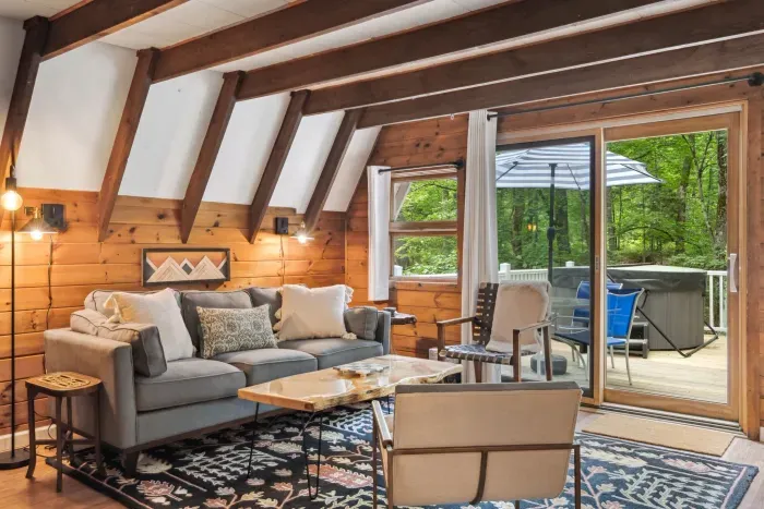 The living area with a full size couch, additional chairs, access to the deck, Smart TV, and mini split heating and cooling!