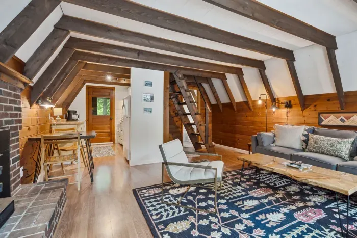 The living area with a couch, additional chairs, access to the deck, Smart TV, and mini split heating and cooling!