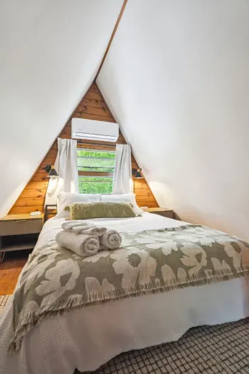 The primary bedroom! Featuring a subtle green theme, mini split heating and cooling, 100% cotton bedding, and blackout curtains. Please note there is no overhead lighting in this room. Clean linens provided.