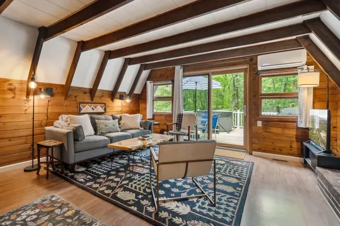 The main living area! There is a smart tv with the ability to login to your own streaming platforms. There is also air conditioning! Access to the deck and hot tub is right out the patio door. Black out curtains throughout