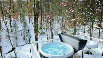 The hot tub is located on the back deck overlooking a stream!