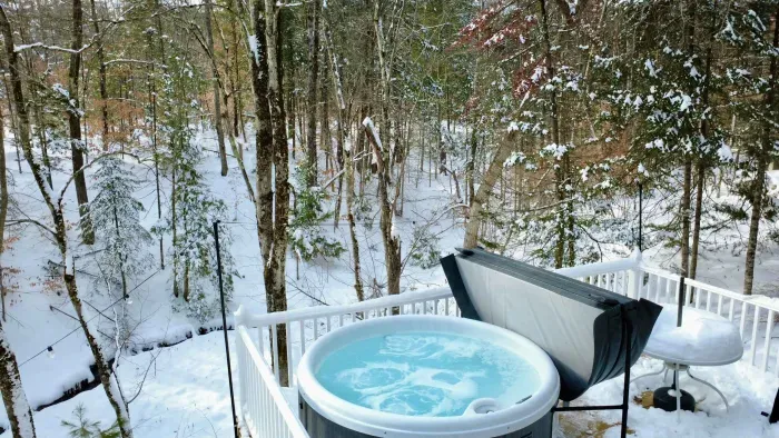 The hot tub is located on the back deck overlooking a stream! 
