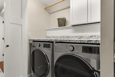 Washer and dryer located in the hallway between the first and second bedrooms on the first level of the house.