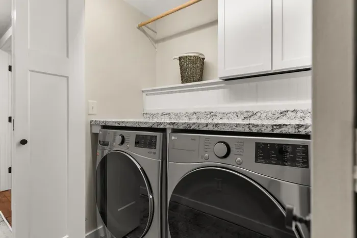 Washer and dryer located in the hallway between the first and second bedrooms on the first level of the house.