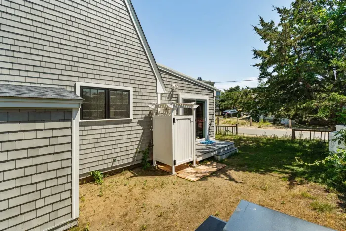 The outdoor shower is located on the backside of the house. There is direct access to the house via the slider here.