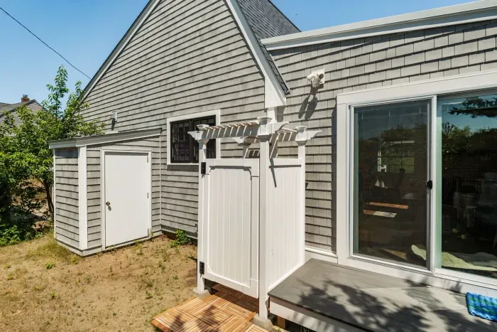 The outdoor shower is located on the backside of the house. There is direct access to the house via the slider here.
