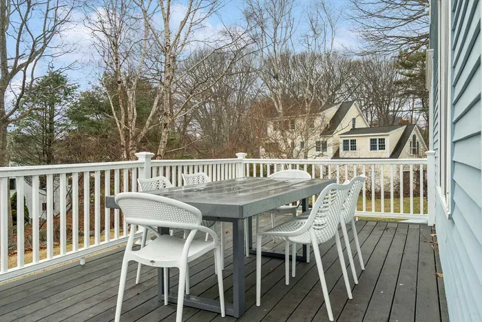Expansive rear deck with gray wicker lounge seating, a dining area, a gas grill, and views of the water! There's an outdoor shower located off the deck also!