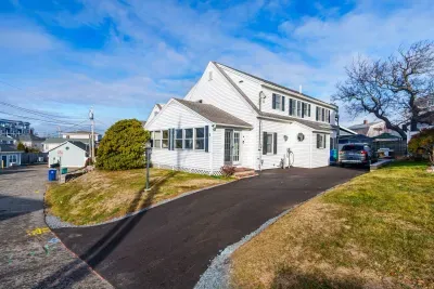 The home from the street, featuring a new driveway and hardscaping! Parking for 3 cars comfortably