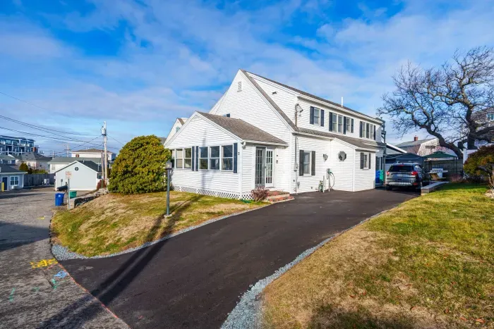 The home from the street, featuring a new driveway and hardscaping! Parking for 3 cars comfortably