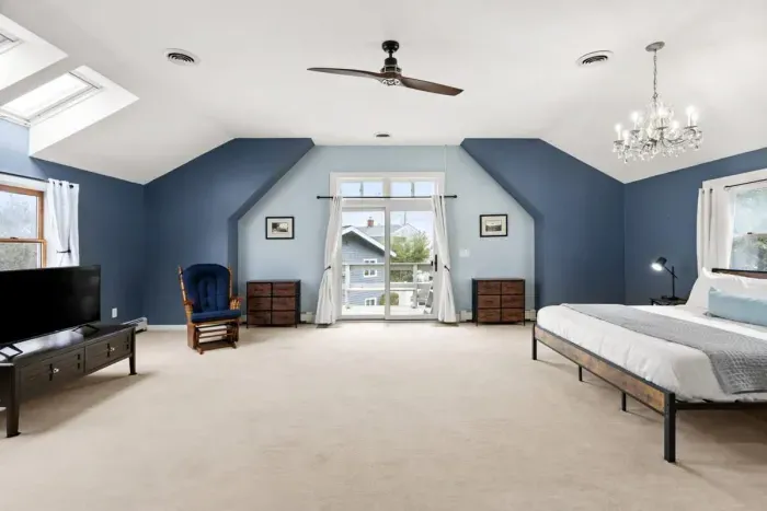 Second level master bedroom with king bed, double doors leading out to private deck & roof deck with views of the Atlantic Ocean