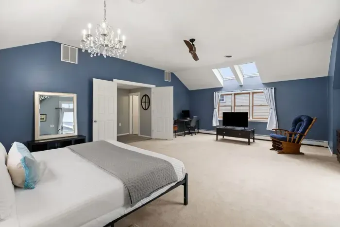 Second level master bedroom with king bed, double doors leading out to private deck & roof deck with views of the Atlantic Ocean