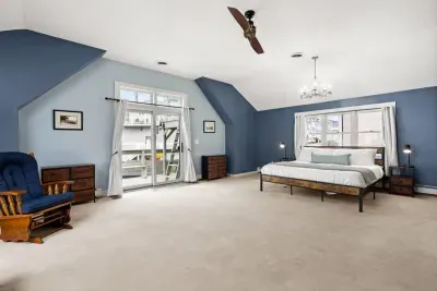 Second level master bedroom with king bed, double doors leading out to private deck & roof deck with views of the Atlantic Ocean