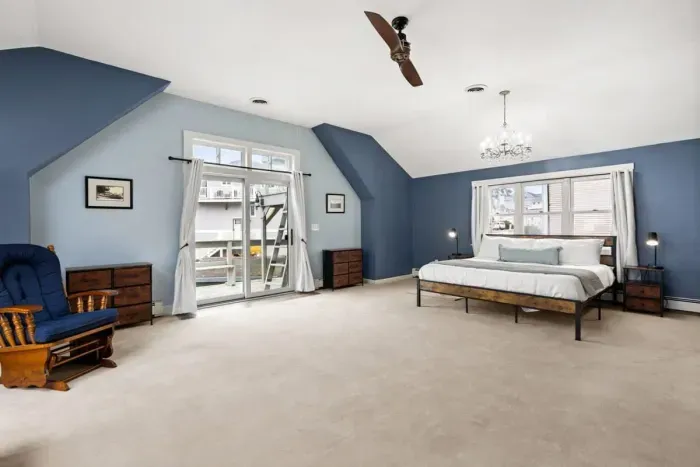 Second level master bedroom with king bed, double doors leading out to private deck & roof deck with views of the Atlantic Ocean