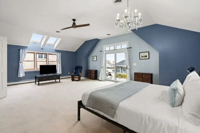 Second level master bedroom with king bed, double doors leading out to private deck & roof deck with views of the Atlantic Ocean