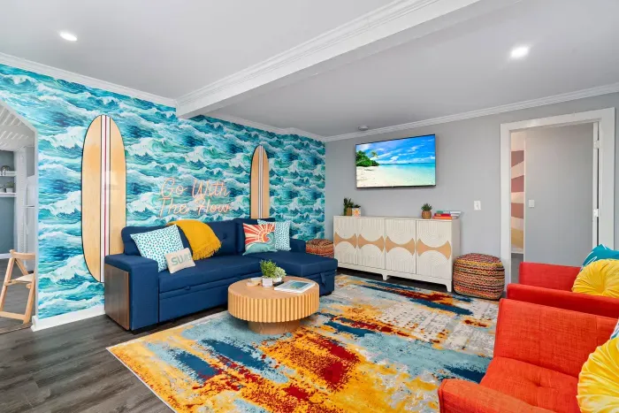 Living Room with "go with the flow" neon light sign, flat screen smart TV and sleeper sofa