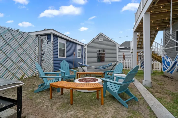 Common back yard area, with common amenities shared with the unit upstairs -- string lights, gas firepit, sitting area, hammock, swinging chairs - WE NO LONGER HAVE A GRILL
