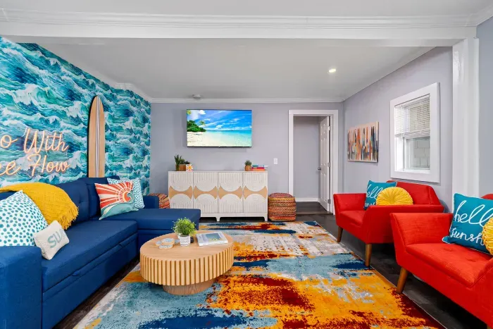 Living Room with "go with the flow" neon light sign, flat screen smart TV and sleeper sofa