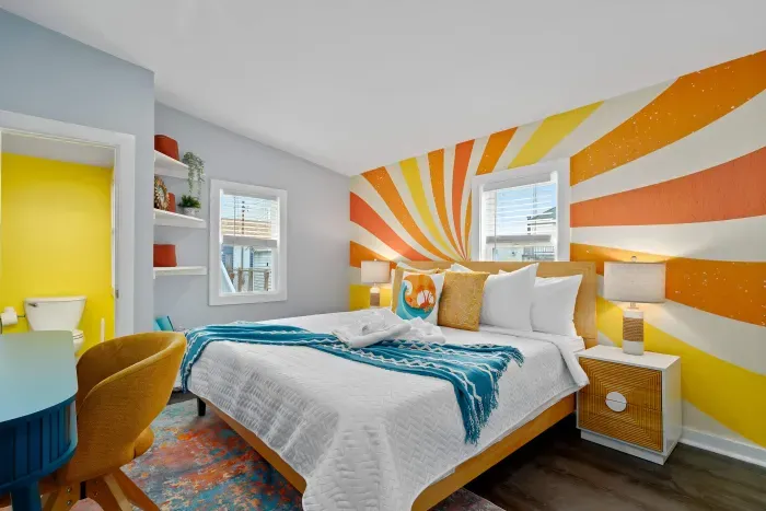 Primary bedroom with king bed, mounted smart TV, closet and work-from-home desk