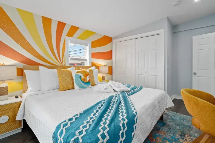 Primary bedroom with king bed, mounted smart TV, closet and work-from-home desk