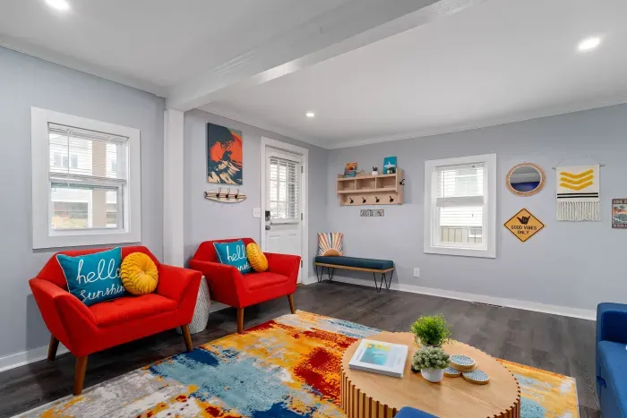 Living Room with "go with the flow" neon light sign, flat screen smart TV and sleeper sofa