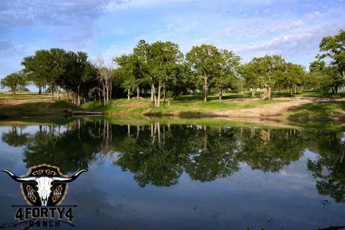 A view of the pond and game center that features a pickleball court