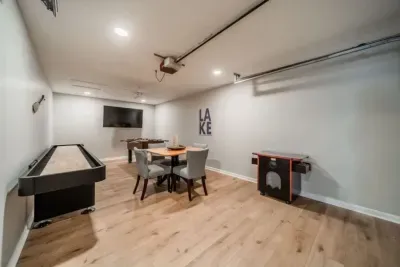Game room with foosball, shuffle board, arcade game, large TV and card table