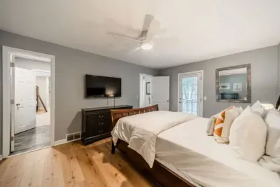 Fourth bedroom with Queen-sized bed, TV, and connected bathroom