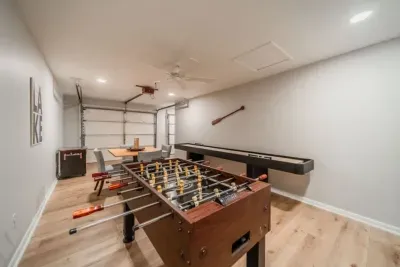 Game room with foosball, shuffle board, arcade game, large TV and card table