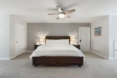 This second-floor bedroom offers a spacious king bed, a TV for relaxing, and a cozy office nook… perfect for work or winding down.