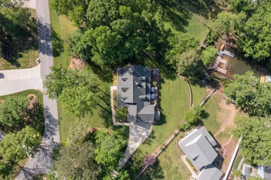 Overhead view of the property with large back yard and driveway.