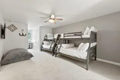 This bedroom is a kid’s dream with two twin and two full-size bunk beds, a TV, giant floor pillows, and a cozy office nook—perfect for fun, relaxation, and their own space!