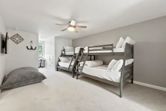 This bedroom is a kid’s dream with two twin and two full-size bunk beds, a TV, giant floor pillows, and a cozy office nook—perfect for fun, relaxation, and their own space!