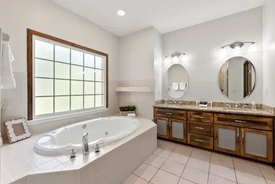 The large ensuite bathroom features double vanities, relaxing jacuzzi, and a large shower ready for use.