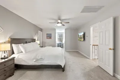 This second-floor bedroom offers a spacious king bed, a TV for relaxing, and a cozy office nook… perfect for work or winding down.