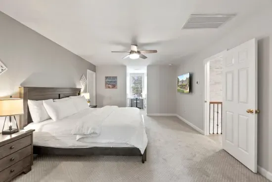 This second-floor bedroom offers a spacious king bed, a TV for relaxing, and a cozy office nook… perfect for work or winding down.