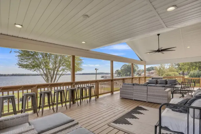 Outdoor dining with barstools and extra wide railing for plates and glasses.