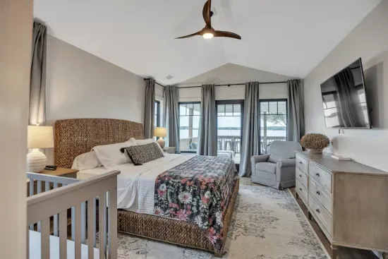 Master bedroom located off the main living area. King size bed, Sony HDTV, direct porch access, and a crib and rocking chair.