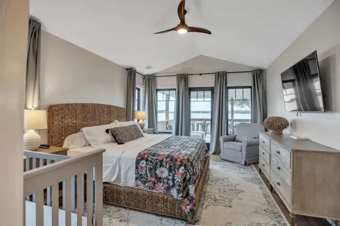 Master bedroom located off the main living area. King size bed, Sony HDTV, direct porch access, and a crib and rocking chair.