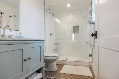 Private ensuite bathroom connected to the downstairs queen bedroom. Custom tile shower.