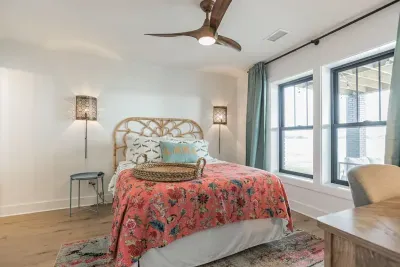 Downstairs queen bedroom with private ensuite bathroom, deep water views, and a desk ready for remote working or school.