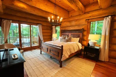 This inviting primary suite blends rustic elegance with comfort, complete with a plush king bed, thoughtful lighting, and direct access to your own private deck with fresh air and quiet surroundings.