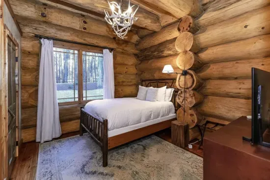 Blending rustic character with modern comfort, this guest bedroom offers a queen bed, inviting textures, and a calm atmosphere ideal for unwinding.