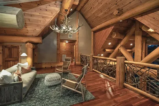 The upstairs common area provides a comfortable gathering space between bedrooms, with cozy seating and rustic elegance—great for kids, games, or late-night conversations.