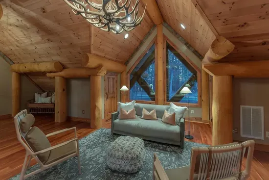 The upstairs common area provides a comfortable gathering space between bedrooms, with cozy seating and rustic elegance—great for kids, games, or late-night conversations.